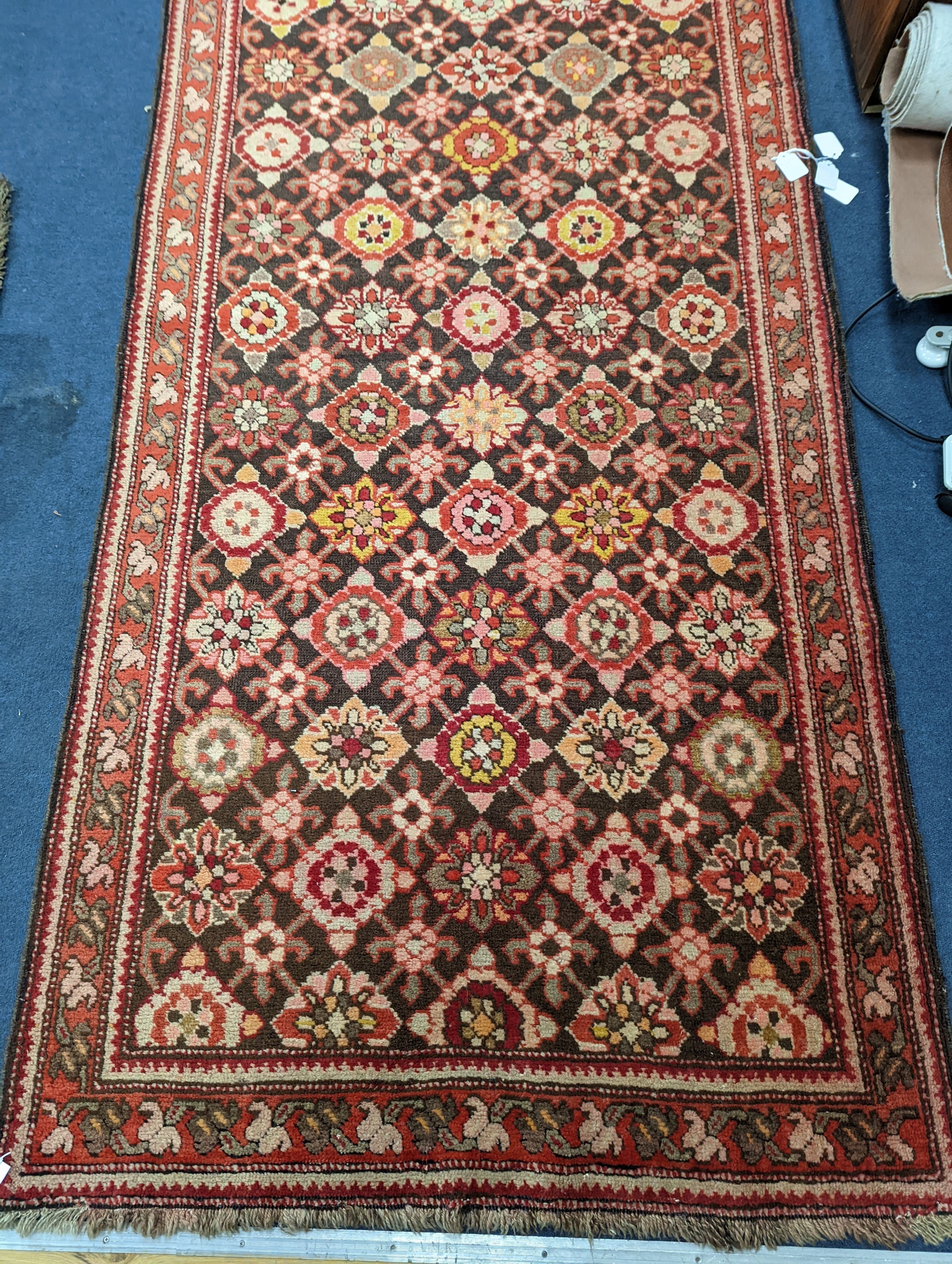 A North West Persian runner woven with rows of floral motifs, 575 x 110cm